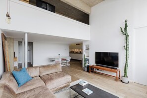 Uma sala de estar moderna com sofá, mesa de centro e televisão de tela plana.