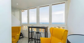 A balcony with a table and two chairs, a view of the sea, and a white railing. - Studio Apartment 'Sea Breeze' with Sea View, Wi-Fi and Air Conditioning (Torrevieja)