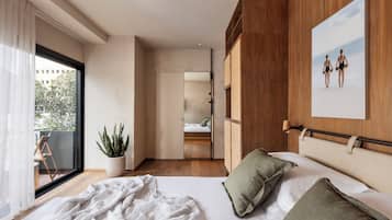A bedroom with a bed, a potted plant, a window with curtains, and a wooden headboard.