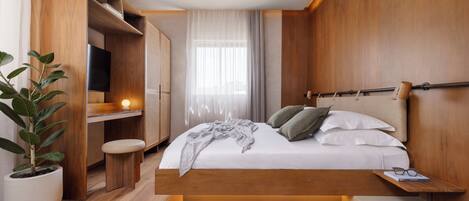 Un dormitorio moderno con cama de madera, mesita de noche y planta en maceta.