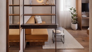 A modern living room with a sofa, a coffee table, and a bookshelf. - The ABY Hotel  (Tel Aviv)