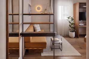 A modern living room with a sofa, a coffee table, and a bookshelf. - The ABY Hotel  (Tel Aviv)