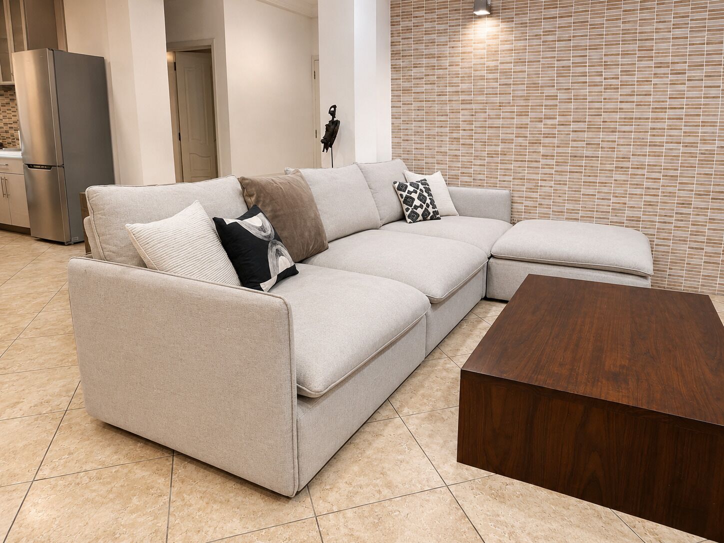 Una sala de estar moderna con un sofá modular, una mesa de centro de madera y piso de baldosas.