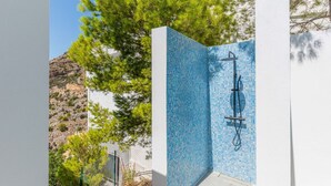 A pool with blue mosaic tiles, a shower area, and a view of a mountainous landscape. - Villa Azita is a spectacular Luxury Villa in Altea Hills, Panoramic Sea Views (Altea)