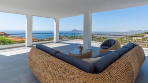 A covered outdoor seating area with wicker furniture and a view of the sea. - Villa Azita is a spectacular Luxury Villa in Altea Hills, Panoramic Sea Views (Altea)