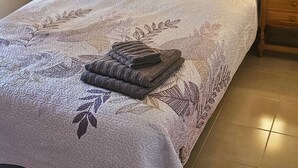 A neatly made bed with a floral-patterned bedspread, two bedside lamps, a framed artwork on the wall, and a wooden headboard. - Holiday Home 'Marolesja' with Mountain View, Wi-Fi and Air Conditioning (Puerto de Mazarrón)