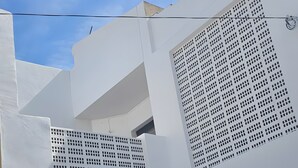 A white building with a balcony, a gated entrance, and a security camera. - Holiday Home 'Marolesja' with Mountain View, Wi-Fi and Air Conditioning (Puerto de Mazarrón)