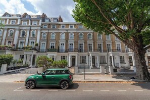 A row of terraced houses with a green car parked in front. - Sunny, 2bed 2bath, garden apartment near Hyde Park (London)