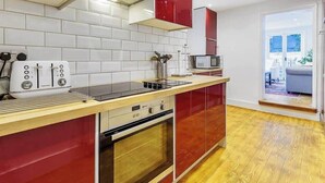 Una cucina moderna con forno integrato, microonde e tostapane.