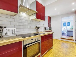 A modern kitchen with a built-in oven, a microwave, and a toaster. - Sunny, 2bed 2bath, garden apartment near Hyde Park (London)