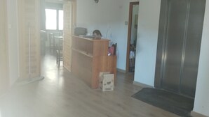 Un espace de vie à aire ouverte avec un plancher en bois, un bureau et un réfrigérateur.