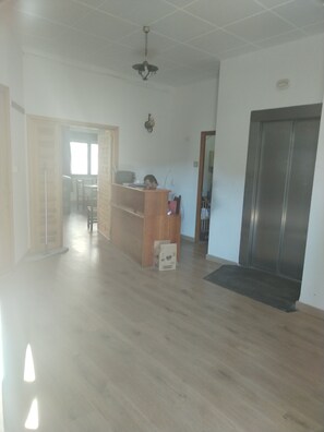 Ein offener Wohnbereich mit Holzboden, einem Schreibtisch und einem Kühlschrank.