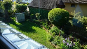 Ein gepflegter Garten mit Rasenfläche, verschiedenen Pflanzen und einem kleinen Schuppen.