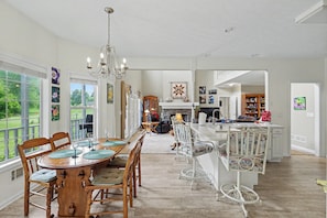 Eine geräumige Küche mit Essbereich, großen Fenstern und einer Chandelier.