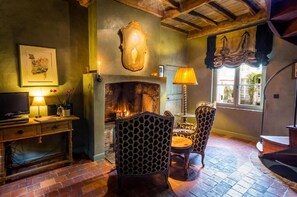 Quarto aconchegante com lareira, móveis de madeira e janela com cortinas.
