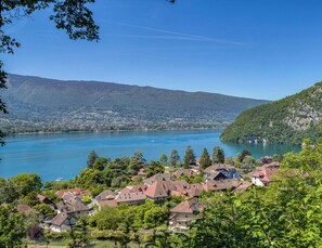 Ein Seeufer-Dorf mit traditionellen Häusern, einem klaren blauen See und umliegenden Hügeln.