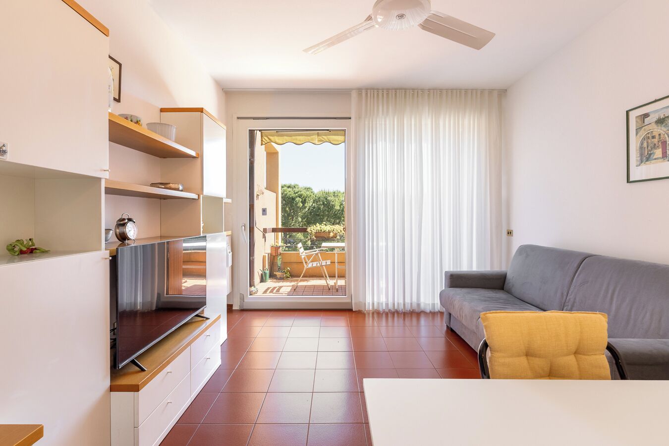 Uma sala de estar moderna com sofá, TV e varanda com vista.