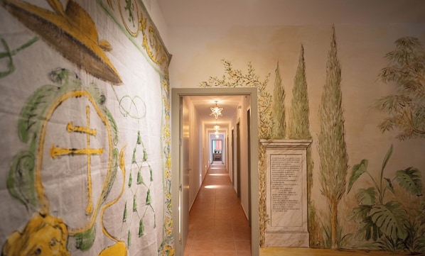 En gang med et mural på venstre side, en stjernelignende lampe i midten og en plade monteret på væggen til højre.