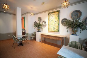 A dining area with a table, chairs, and decorative plates on the wall.