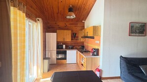 A wooden interior with a kitchen, a dining area, and a sofa. - Chalet Douglas - 30 People (Châtillon-Saint-Jean)