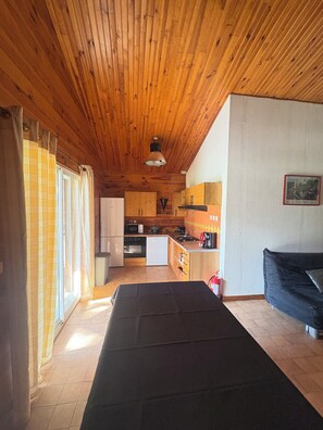 Un intérieur en bois comprenant une cuisine, un coin repas et un canapé.