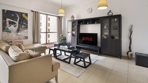 A living room with a sofa, coffee table, TV, and decorative items. - Spacious 2 Bedroom Apt in Sadaf JBR  (Dubai)