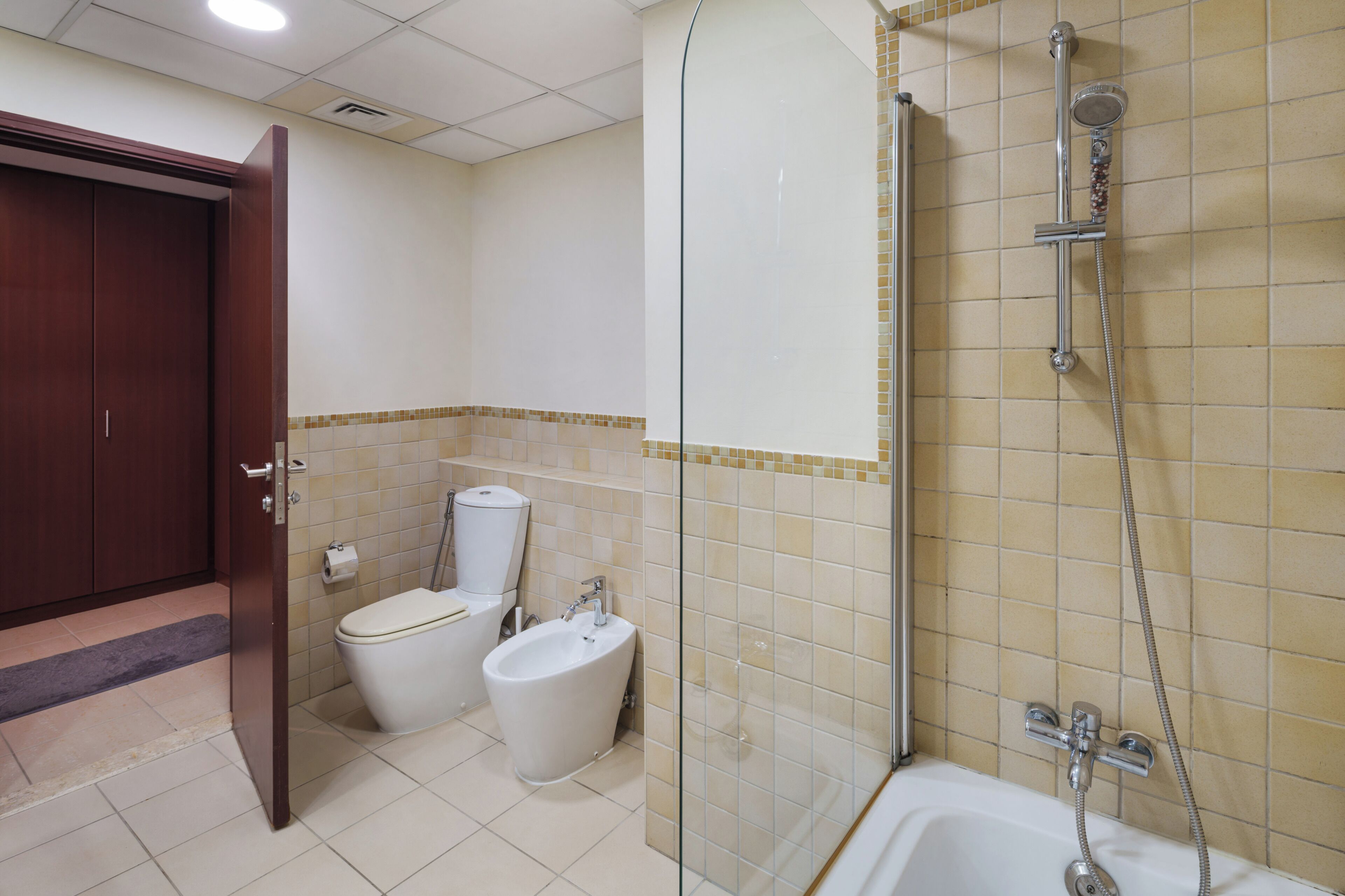 Un bagno con il water, un bidet e una doccia con cabina in vetro.