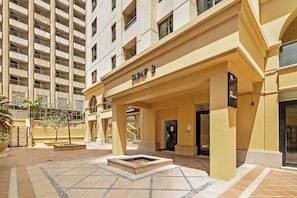 A hotel entrance with a sign reading 'SADAF 2', a covered outdoor area, and a water feature. - Spacious 2 Bedroom Apt in Sadaf JBR  (Dubai)