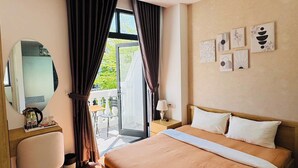 Una camera d'albergo con un letto, una scrivania, una sedia, uno specchio e opere d'arte alle pareti.