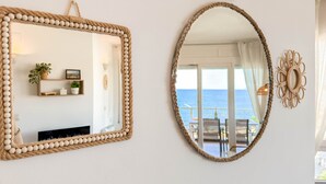 A room with a large mirror with a rope frame, a smaller mirror with a rope frame, and a decorative wall piece. - Maricel apartment with pool and sea views (L'Escala)