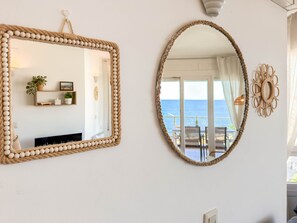 Ein Zimmer mit einem großen Spiegel mit Seilrahmen, einem kleineren Spiegel mit Seilrahmen sowie einer dekorativen Wandverziierung.
