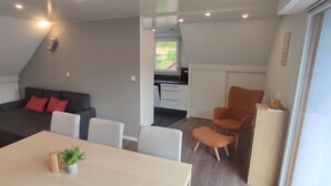 A modern living space with a sofa, dining table, and kitchen area. - The edge of the vineyard - the balcony (Andlau)