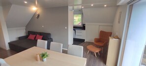 A modern living space with a sofa, dining table, and kitchen area. - The edge of the vineyard - the balcony (Andlau)