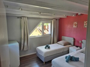 A small, single-room accommodation with a bed, a bedside table, a lamp, and a window with curtains. - At the Edge of the Vineyard—The Balcony (Andlau)