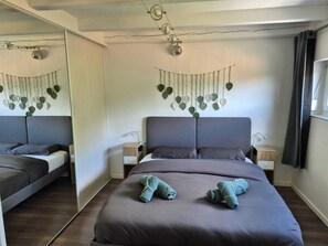 A modern bedroom with a large bed, two bedside tables, and a wall-mounted light fixture. - At the Edge of the Vineyard—The Balcony (Andlau)