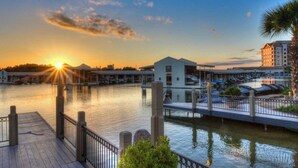 A waterfront hotel with a dock, a building with a flat roof, and a parking area. - Dog-friendly & spacious condo with lake views, large balcony, & Pool (Horseshoe Bay)
