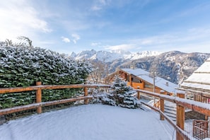 A snow-covered wooden deck with a view of snow-capped mountains in the background. - La Casa Di Olaf With Garden (Bardonecchia)