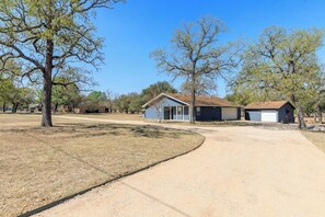 A residential area with houses, a driveway, and trees. - Secluded, Dog-Friendly Getaway w/ Beautiful Views, a Large Yard, & Free WiFi (Fredericksburg)