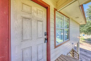 Ein Haus mit VordertĂŒr, Fenster und einer Holzterrasse.