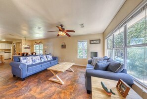 Ein gerÀumiges Wohnzimmer mit zwei Sofas, einem Holztisch und einem Deckenventilator.