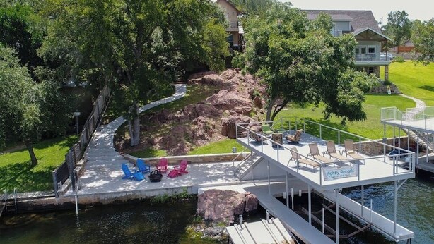 A dock with a deck, chairs, and a sign for nightly rentals.
