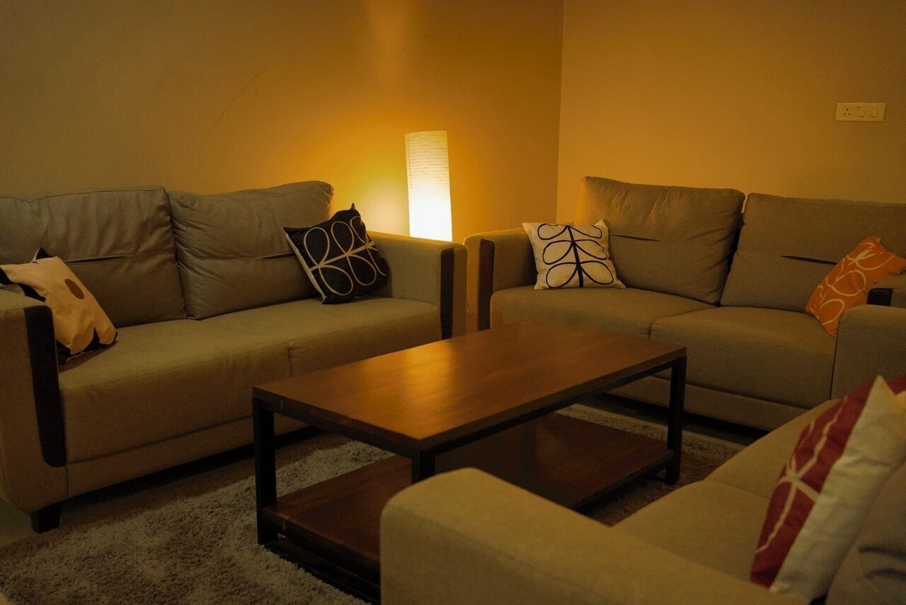 A living room with two sofas, a coffee table, and a lamp.