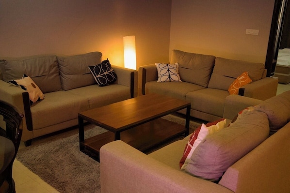 Un salon avec deux canapés, une table basse et une lampe.