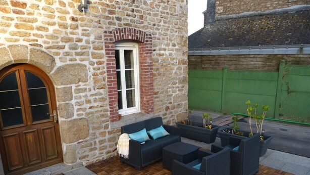 A stone building with a wooden door, a window, and outdoor seating with planters. - Le50300 Gîte for 5 pers in Avranches, close to Mont Michel ! (Avranches)