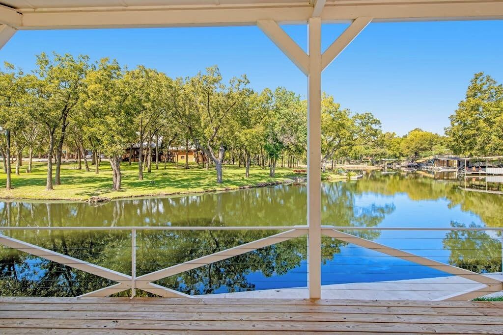 Un espace extérieur abrité offrant une vue sur un lac et des arbres.