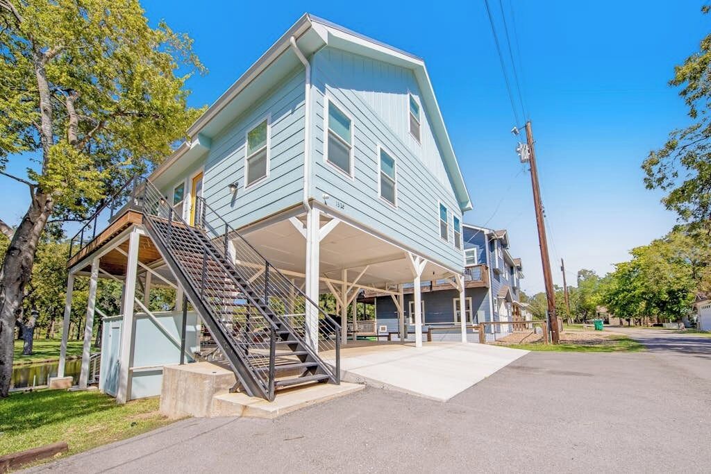 A two-story house with a covered porch and a staircase leading to the upper floor.