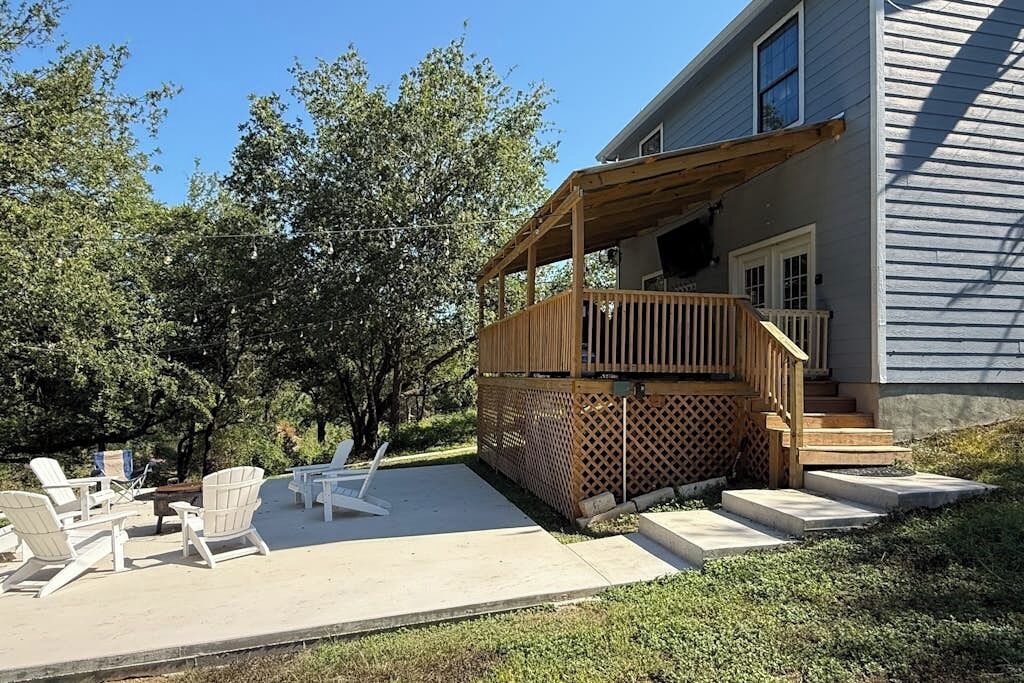 Ein Haus mit einer Holterrasse, Sitzgelegenheiten im Freien und einer überdachten Veranda.