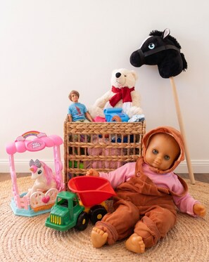 A doll surrounded by toys and a wicker basket. - Cozy and Modern Villa with Sauna - perfect for groups and families (Rovaniemi)