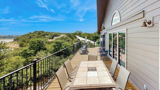 Ein Balkon mit Tisch und Stühlen, mit Blick auf eine reizvolle Landschaft.
