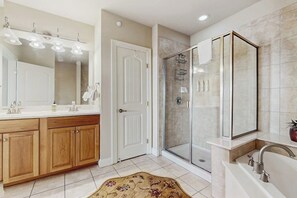 A modern bathroom with a shower, a vanity with a mirror, and a bathtub. - Lake LBJ Waterfront Escape | Marina Views (Horseshoe Bay)